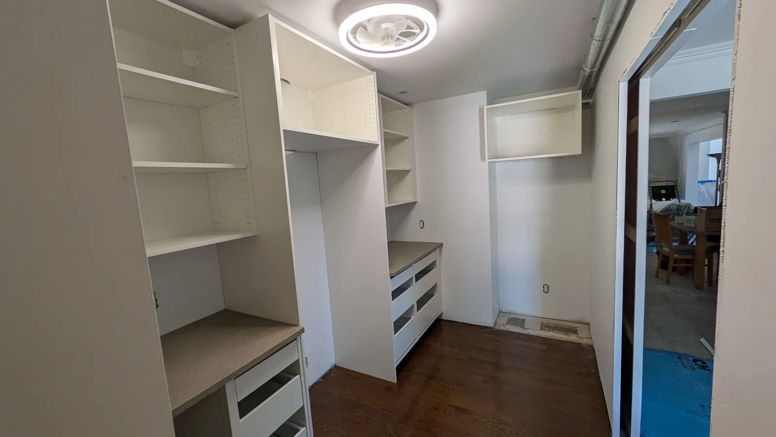 Tall cabinet, shelving and drawer units along the wall of a walk-in pantry in Laval