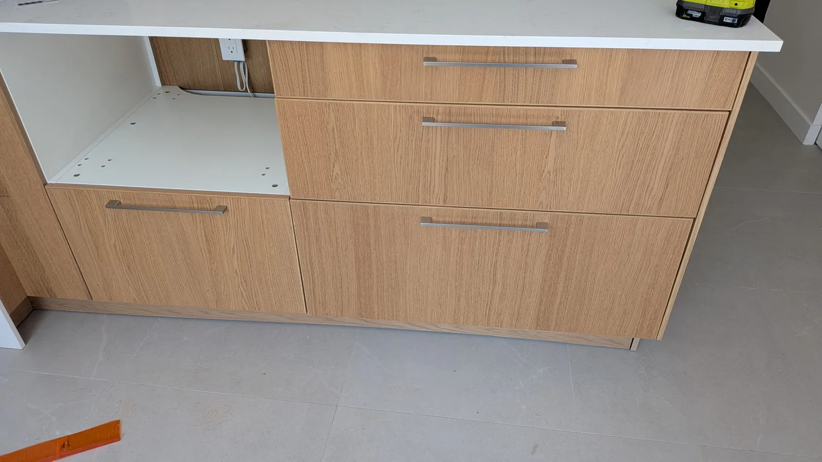 Oak-finish drawer base cabinets with stainless bar handles in a Brossard kitchen installation